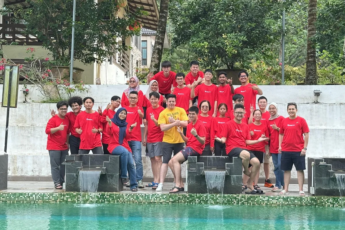 The Radiant Communication team in matching red T-shirts, gathered by a pool at a company retreat.